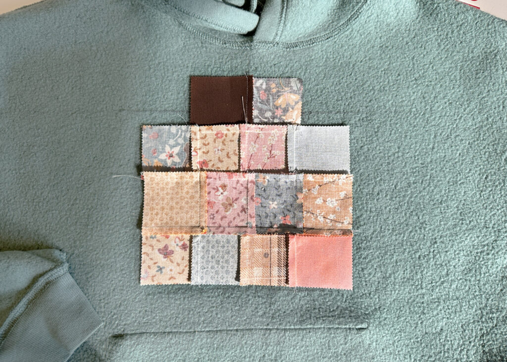 Mini Charm pack patchwork block centered on plain hoodie for NE210 Applique project