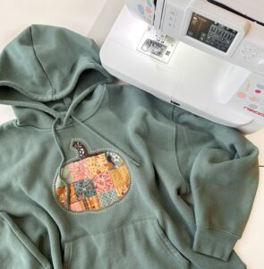 Completed patchwork pumpkin appliqué sweatshirt made with NECCHI NE210 sewing machine